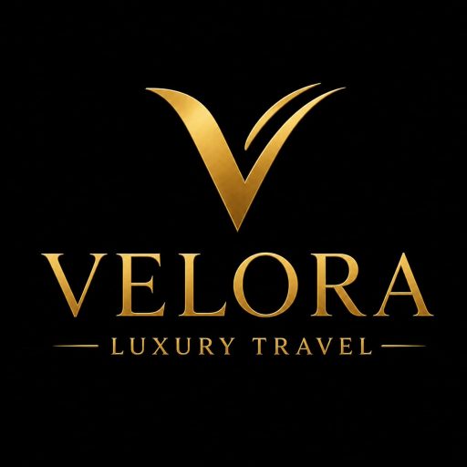 Logo Velora Luxury Travel emas dengan latar belakang hitam